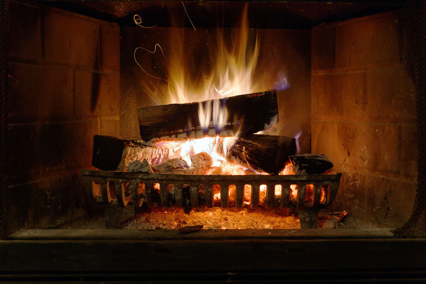 Firewood burning with a fireplace grate.